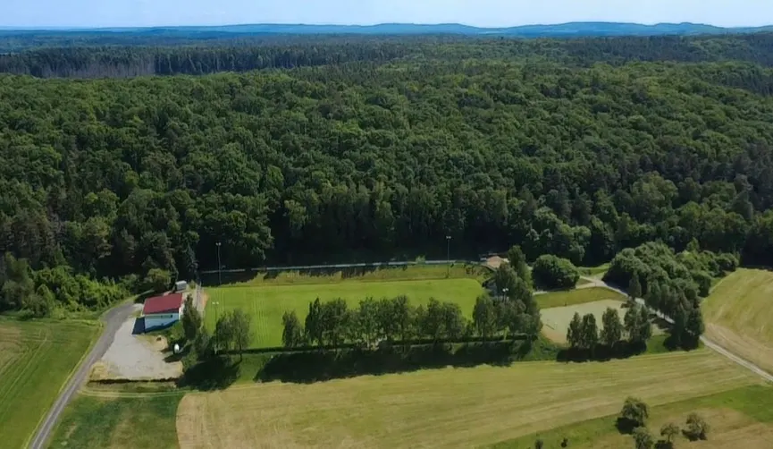 Luftbild des Sportplatzes „Am Pleckers“ mit umliegendem Wald